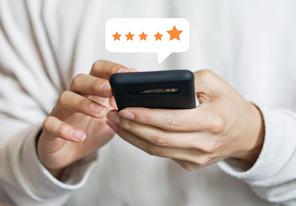A person holding a cell phone leaving a five star review