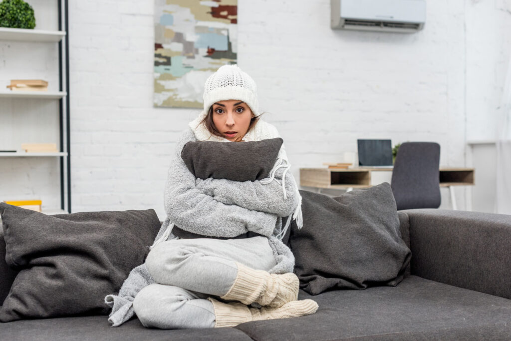 A woman sitting on a couch in winter clothes