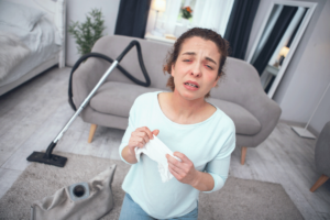Woman sneezing from vacuuming